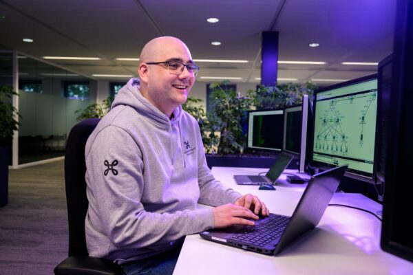 man sitting behind a desk working on a laptop